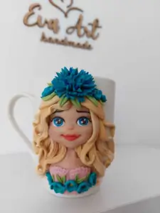 Cană handmade decorată cu figurină de fată blondă și floare albastră, design floral artistic